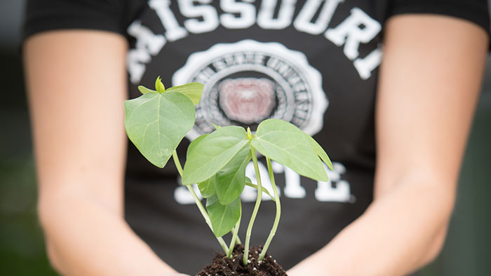 Student holding plant