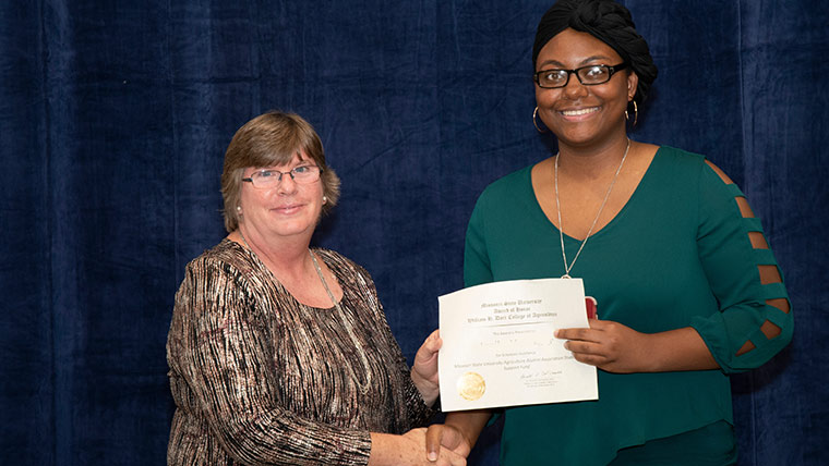 Animal science major accepting a scholarship during banquet ceremony.