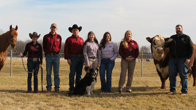 Animal science faculty posing with a horse, dog and cow.