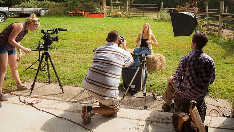 An agriculture student being filmed on set at the farm.