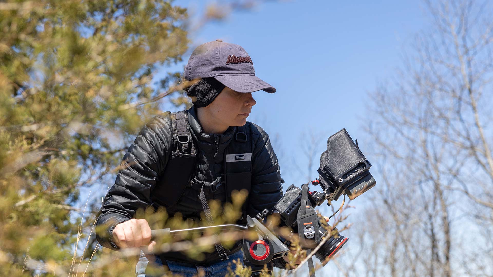 A videographer filming in the woods.