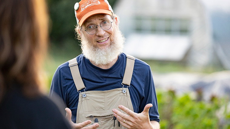 A farmer at Millsap Farm talking to a guest.