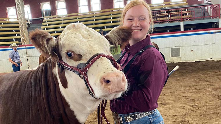 A happy, smiling student with her cow at the Missouri State Fair in Sedalia.