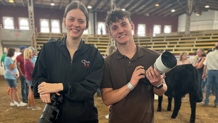 Two students posing with their cameras while doing photography at the Missouri State Fair in Sedalia.