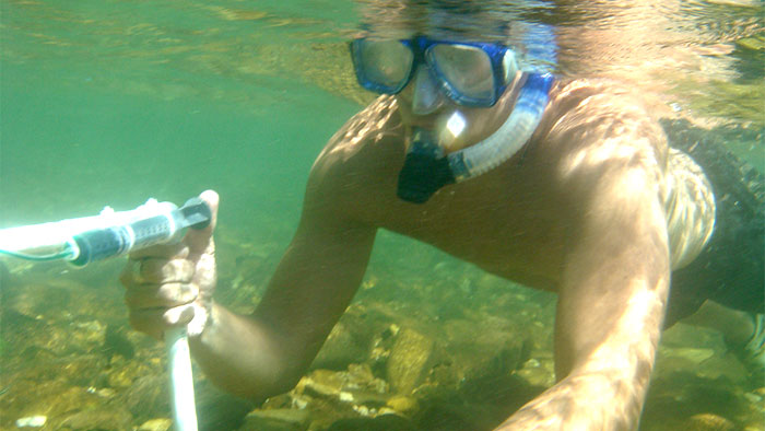 Student with snorkel collecting water sample