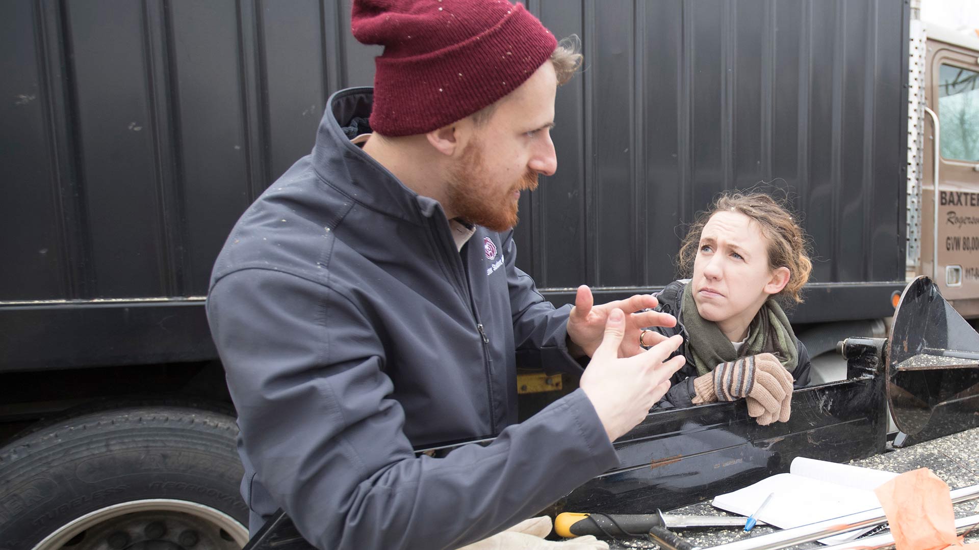 Two ag students talk while working at a soybean harvest at a local farm.