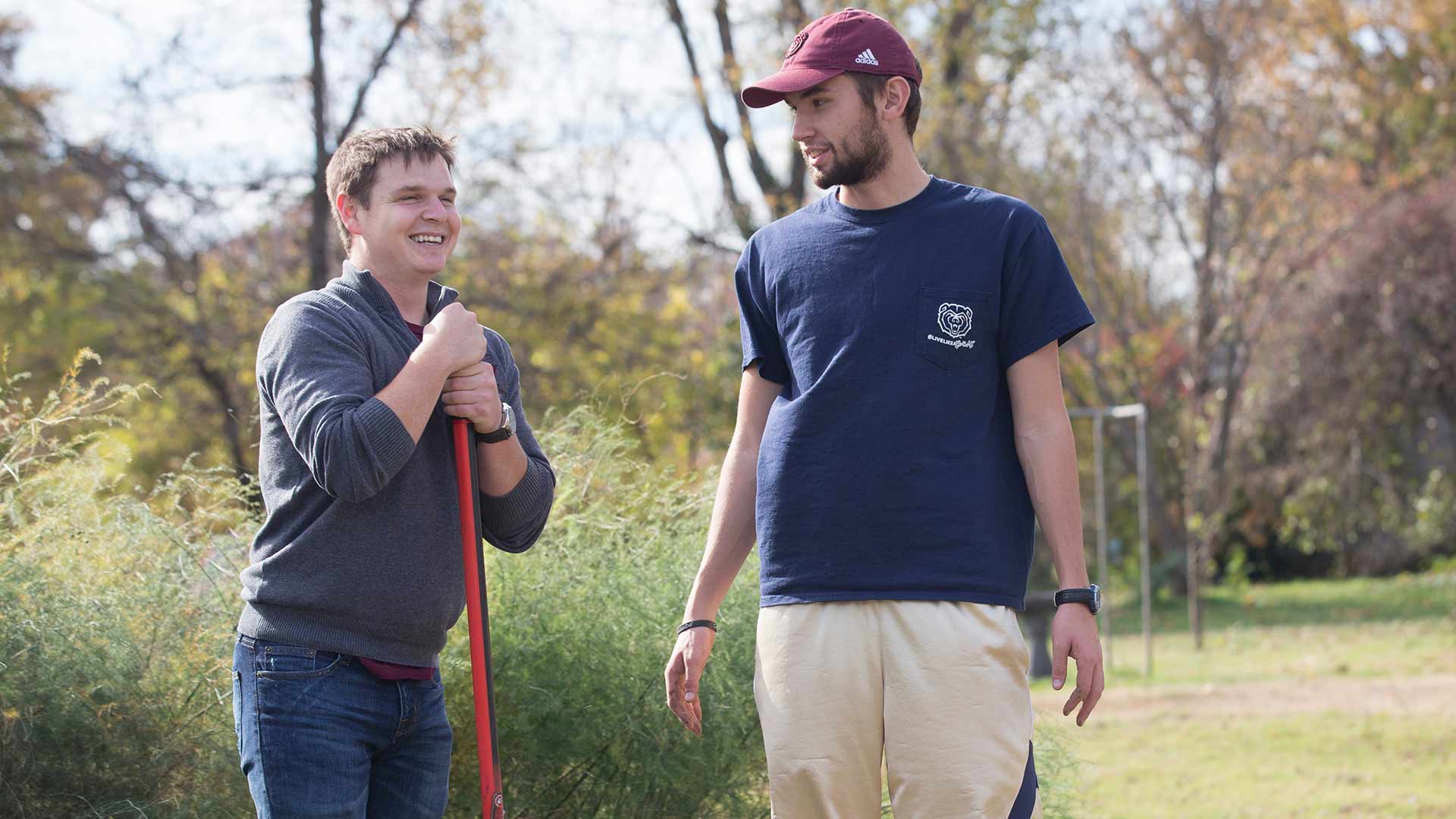 Two students taking a break while working in the community garden on campus.