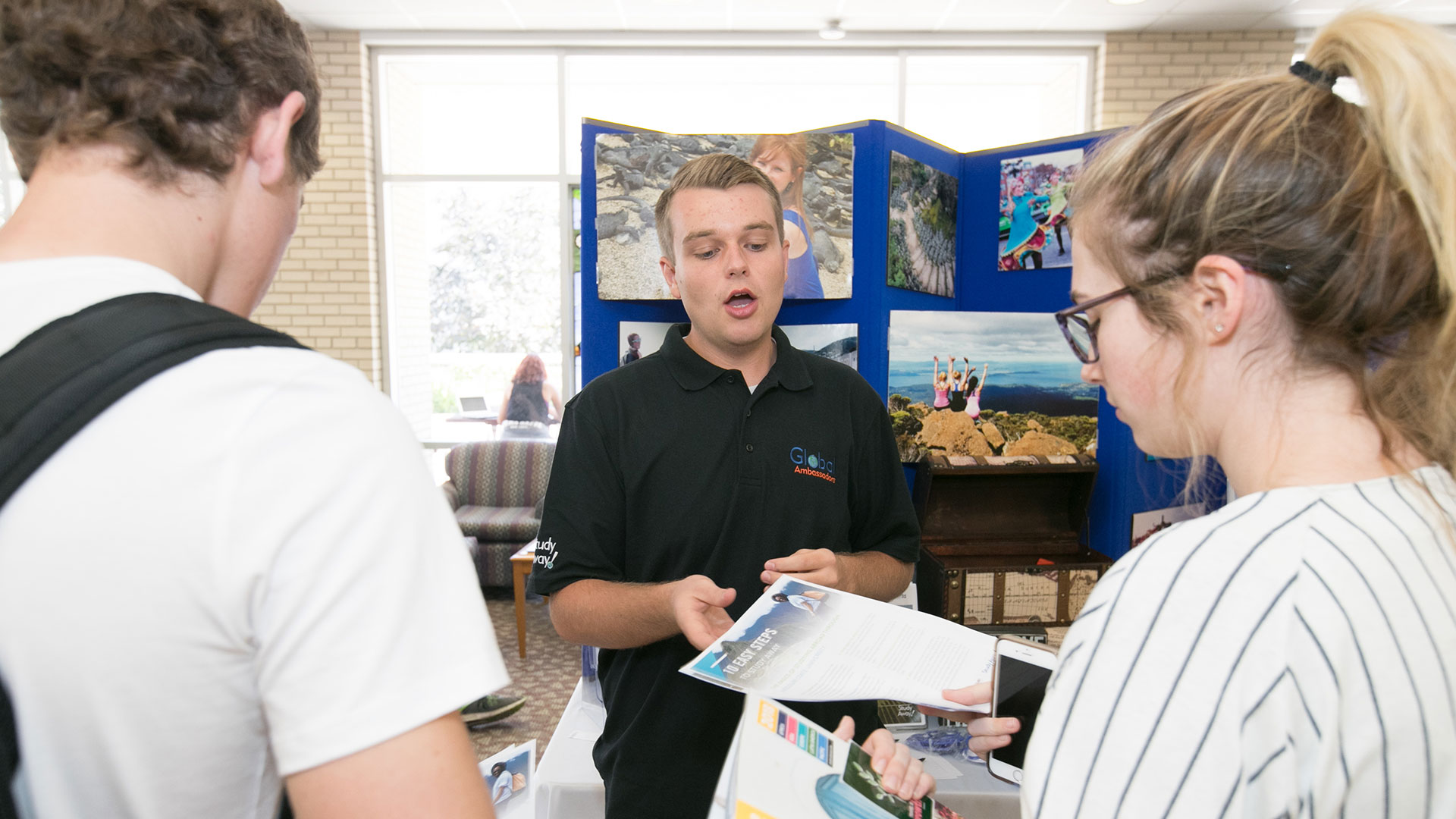 A Study Away rep hands out informational documents about education abroad opportunities.