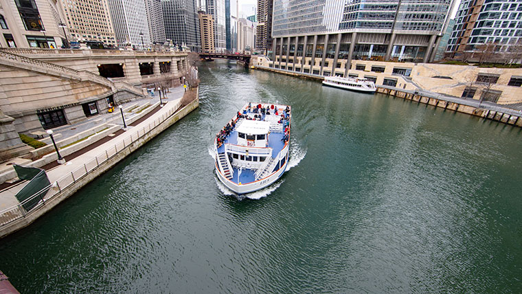 Tourists aboard a ship take in the views of the Chicago skyscrapers along the river.