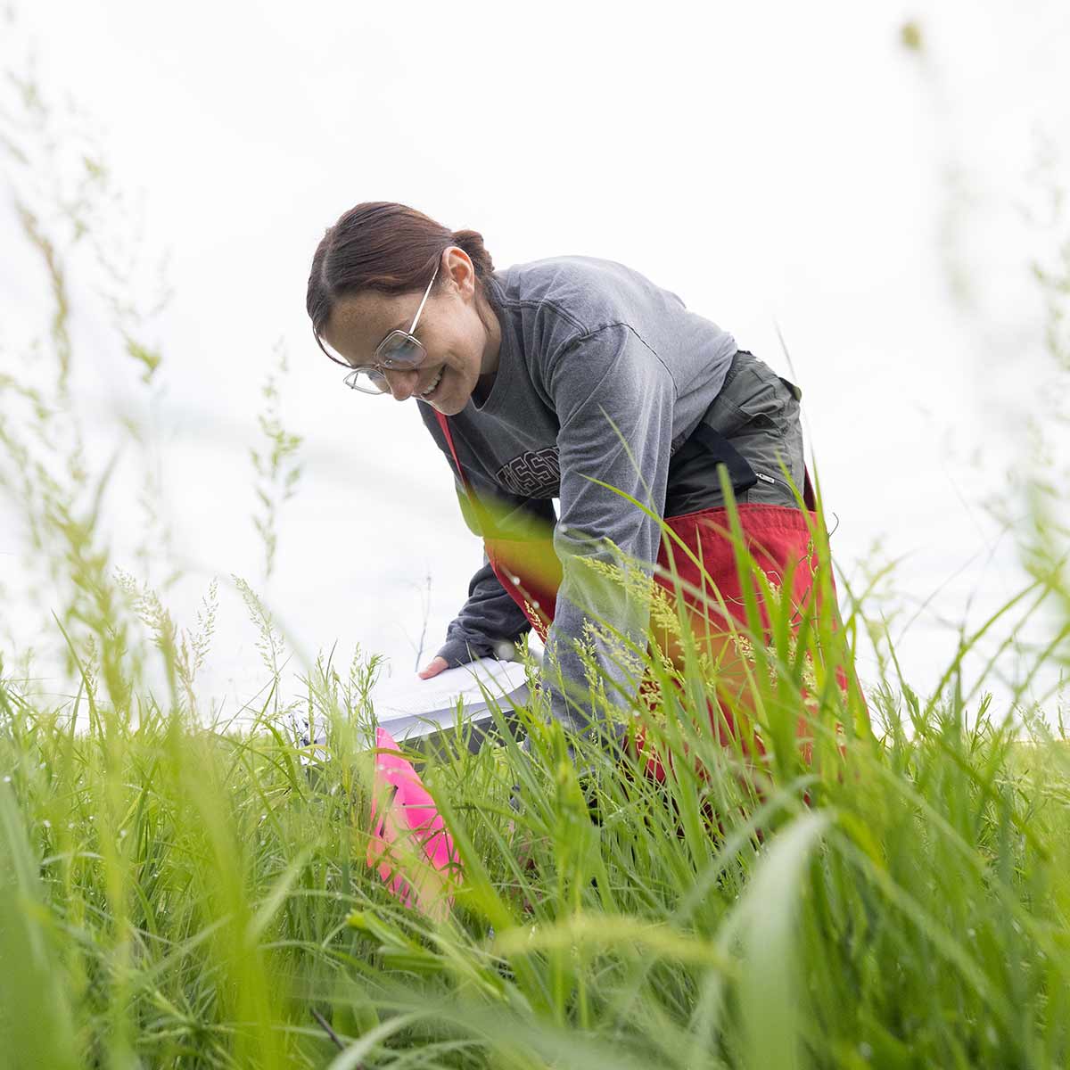 A student conducts a soil check in a prairie.