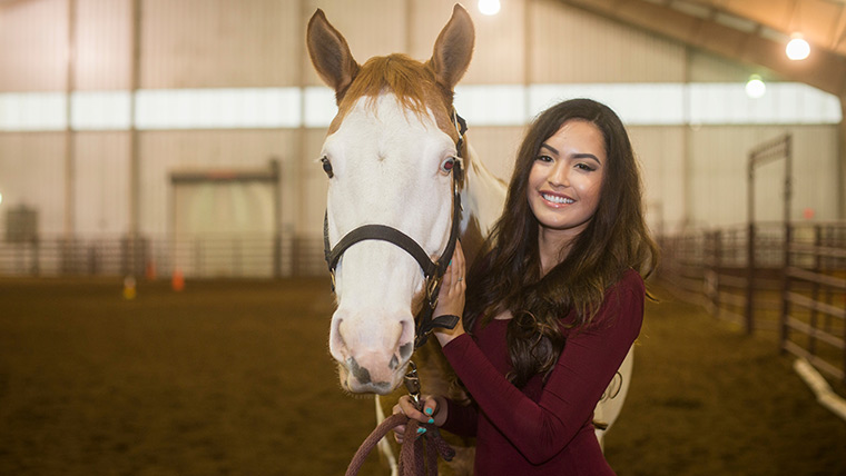 Student handling a horse.